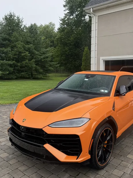 Orange Lamborghini Urus with carbon hood after an exterior detail